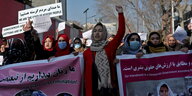 Frauen mit Transparenten bei einer Demonstration.