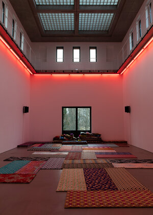 Blick in den Kunstraum, rötliches Licht, Teppiche/Stoffe am Boden Blick in den Kunstraum, rötliches Licht, Teppiche/Stoffe am Boden