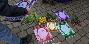 Blumen und Flyer liegen auf dem Asphalt. "#keinemehr"