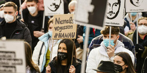 Bei einer Demo halten Menschen Plakate hoch mit der Schrift Eine Teilnehmerin hält ein Plakat «niemals vergessen#Hanau» und mit den Portraits der Opfer des Anschlags