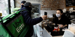 Ein Crowdworker holt eine Lieferung in einem Café ab