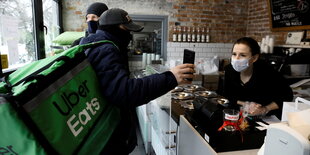 Ein Crowdworker holt eine Lieferung in einem Café ab