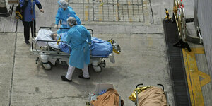 Patienten liegen im Freien vor dem Krankenhaus auf Krankenhausbetten