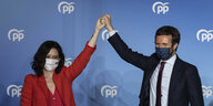 Die Madrider Regierungschefin Díaz Ayuso und der PP-Vorsitzende Pablo Casado halten ihre Hände hoch.