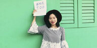 Sophia Huang Xueqin hebt einen Zettel mit der Aufschrift #METOO hoch