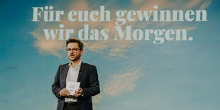 Thomas Kutschaty vor einer Wand mit Himmel und Wolken und dem Text "Für euch gewinnen wir das Morgen"