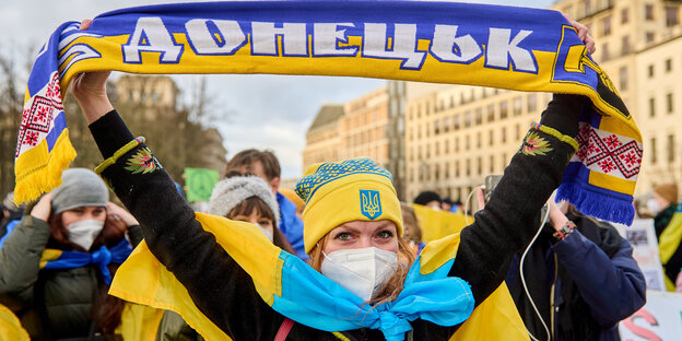 Eine Demonstrantin mit ukrainischer Fahne und Donezk-Schal