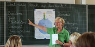 Lehrerin Johanna Evers steht 2009 vor einer Tafel in einer Schulklasse und zeigt auf saterfriesische Worte.