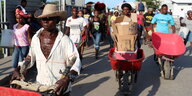 Haitianer transportieren Waren mit Schubkarren