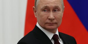 Präsident Putin vor einer russischen Flagge