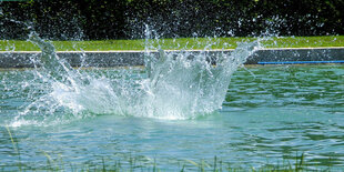 Wasser spritzt hoch im Freibad