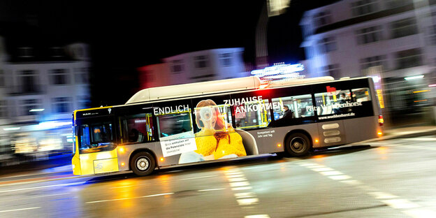Ein Linienbus fährt durch die Stadt bei Nacht