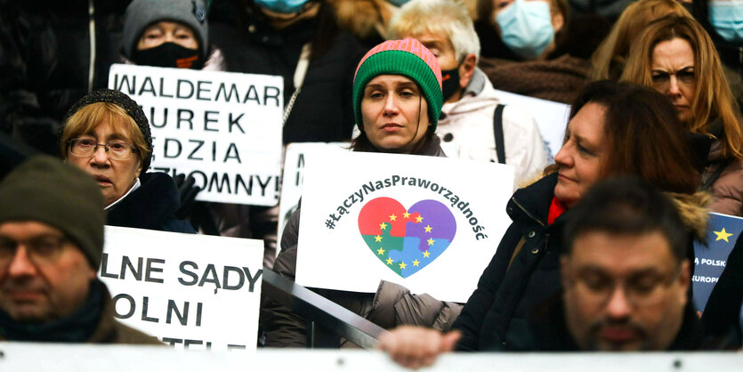 Menschen protestieren mit Schildern und Plakaten