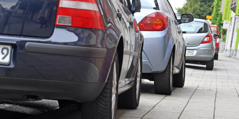 Autos parken halbseitig auf einem Bordstein