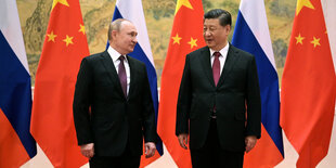 Der chinesische Präsident Xi Jinping (r) und der russische Präsident Wladimir Putin stehen zusammen vor den Flaggen Chinas und Russlands