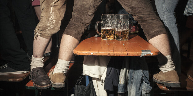 Beine in Lederhosen auf einer Bierbank