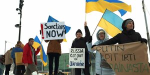 Menschen mit Schildern, u.a. "Sanctions now"