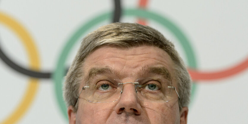 IOC-Chef Thomas Bach sitzt in einer Pressekonferenz