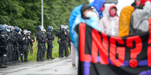 Demonstrierende mit einem Banner, Aufschrift "LNG?", daneben eine Polizeieskorte