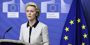 Ursula von der Leyen neben EU-Flagge