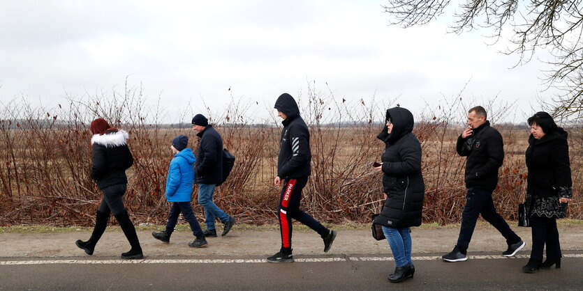 eine Gruppe von Menschen auf einer Landstraße unterwegs