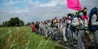 Protest in weissen Schutzanzügen und pinkfarbiger Flagge