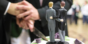 Zwei Männer schneiden nach ihrer Eheschliessung im Rathaus von Hamm eine Hochzeitstorte an.