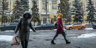 Zwei Frauen unterwegs im Schnee vor der russischen Zentralband in Moskau
