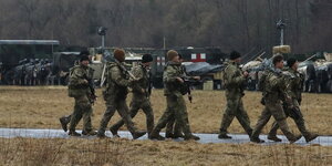 US-Soldaten marschieren bewaffnet auf einem Stützpunkt