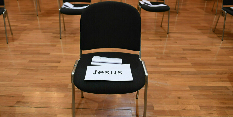 Eine scharzer Stuhl mit einem Platzhalterschild "Jesus"