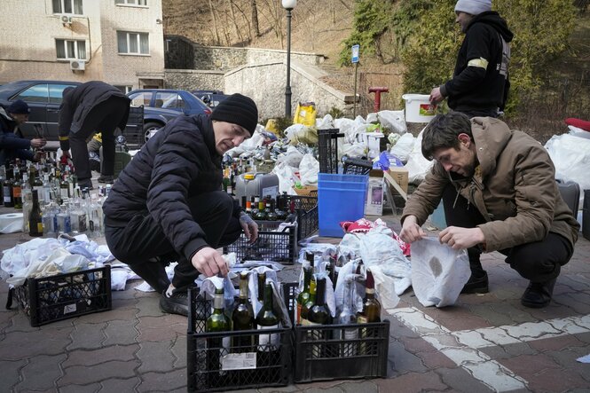 eine Gruppe Männer bereitet Flaschen zu Molotow-Ckocktails auf