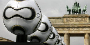 Eine Reihe von Fußbällen vor dem Brandenburger Tor