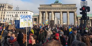 Menschen stehen vor dem Brandenburger Tor