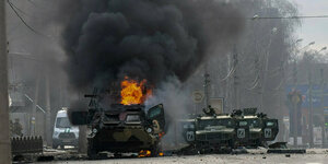 Ein brennendes Armeefahrzeug steht in Charkiw