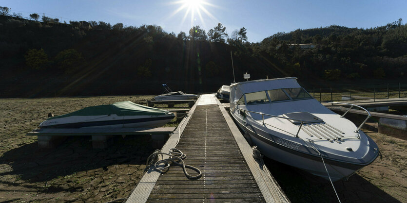 Boote an einem Steg, die auf dem Trockenen liegen.