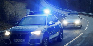 Polizeifahrzeuge mit Blaulicht auf einer Landstraße.