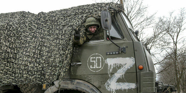 Ein Soldat schaut aus dem Fenster eine Militärlastwagens.