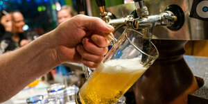 Das Bild zeigt ein Bierglas an einem Zapfhahn.