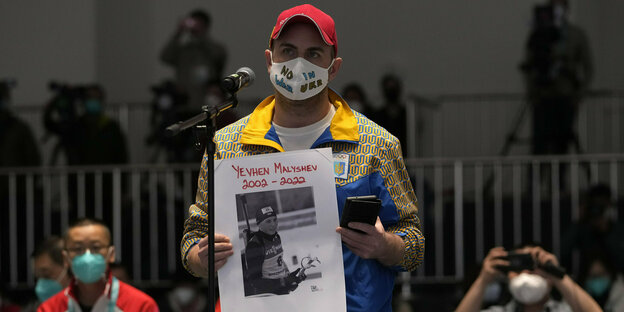 Ukrainischer Journalist mit Plakat am Mikrofon