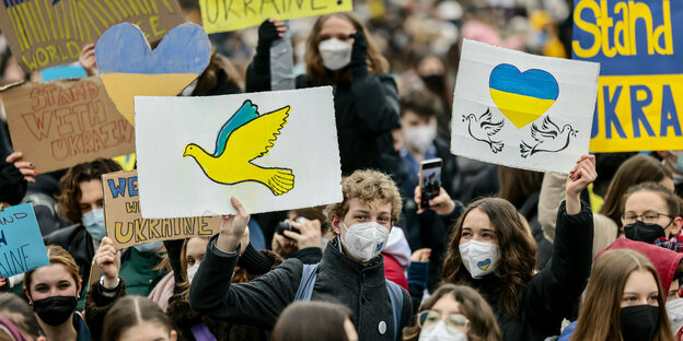 Teilnehmer:innen der Fridays-for-Future-Demo halten Plakate in den ukrainischen Farben hoch Teilnehmer:innen der Fridays-for-Future-Demo halten Plakate in den ukrainischen Farben hoch