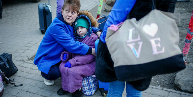 Eine Frau hält ein Kind im Arm