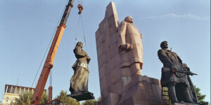 Mit einem Kran wird eine Statue vom Lenindenkmal in Kiew entfernt