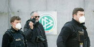 Polizeibeamte laufen am DFB-Logo vorbei