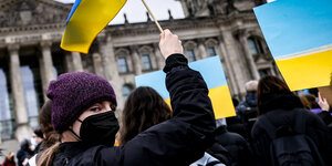 Eine Frau vor dem Brandenburger Tor hält eine ukrainische Flagge in die Luft: Auf der Demo von Fridays for Future am Donnerstag mitten in Berlin