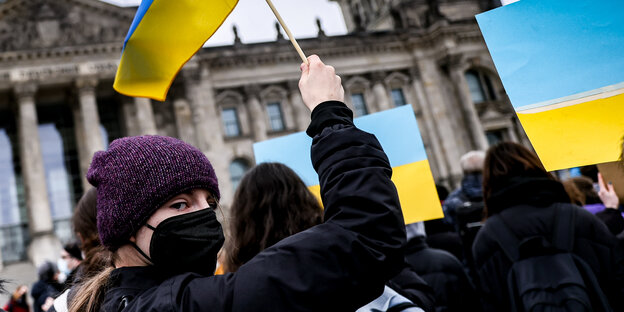 Eine Frau vor dem Brandenburger Tor hält eine ukrainische Flagge in die Luft: Auf der Demo von Fridays for Future am Donnerstag mitten in Berlin