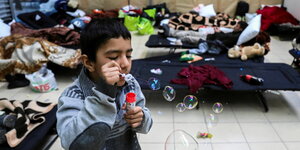 Ein Junge in einem Raum spielt mit Seifenblasen