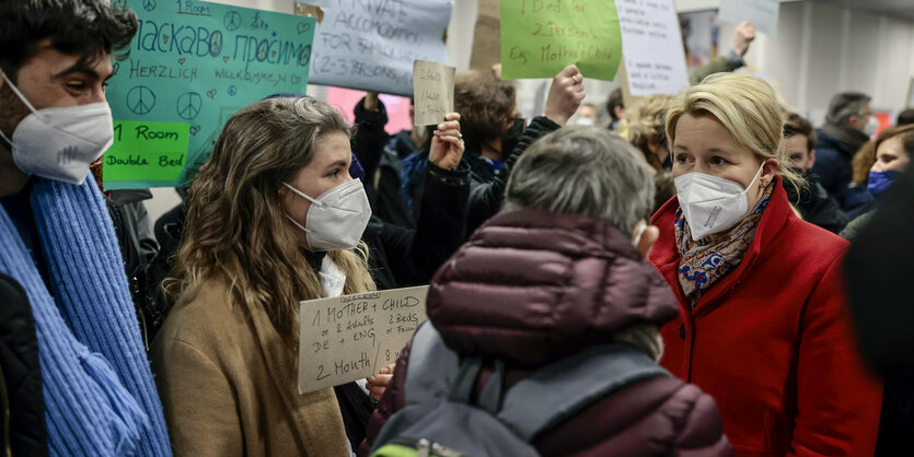 Franziska Giffey steht zwischen Menschen, die aus der Ukraine geflüchtet sind