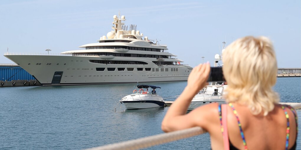 Eine Frau fotografiert eine Luxusyacht