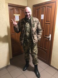 Dmytro N in Militäruniform im Hausflur vor zwei Wohnungstüren Dmytro N in Militäruniform im Hausflur vor zwei Wohnungstüren
