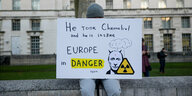 ein Demonstrant trägt ein Schild mit der Aufschrift : " Er hat Tschernobyl eingenommen und er ist wahsinnig. Europa ist in Gefahr."